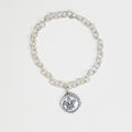 Silver chain bracelet with a fleur-de-lis charm on a white background