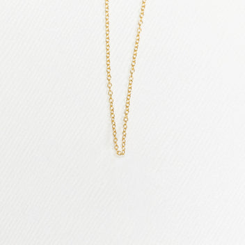 a gold chain on a white surface