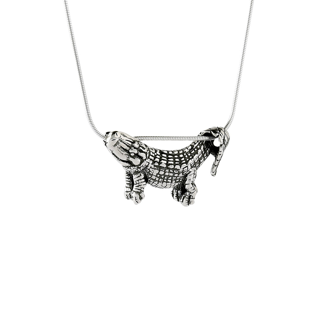 A sterling silver pendant in the shape of an alligator designed to dangle from a chain, with focus on the pendant against a light background.