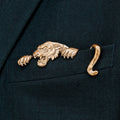 A gilded bronze magnetic pocket square featuring a tiger, affixed to a black fabric jacket pocket.