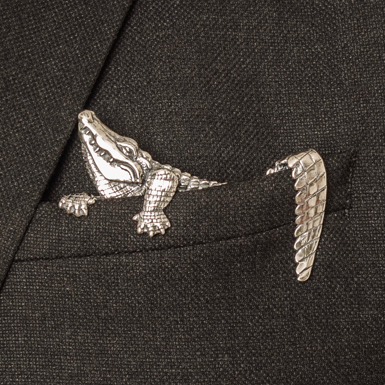 Sterling silver alligator pocket square worn in dark textured suit jacket pocket