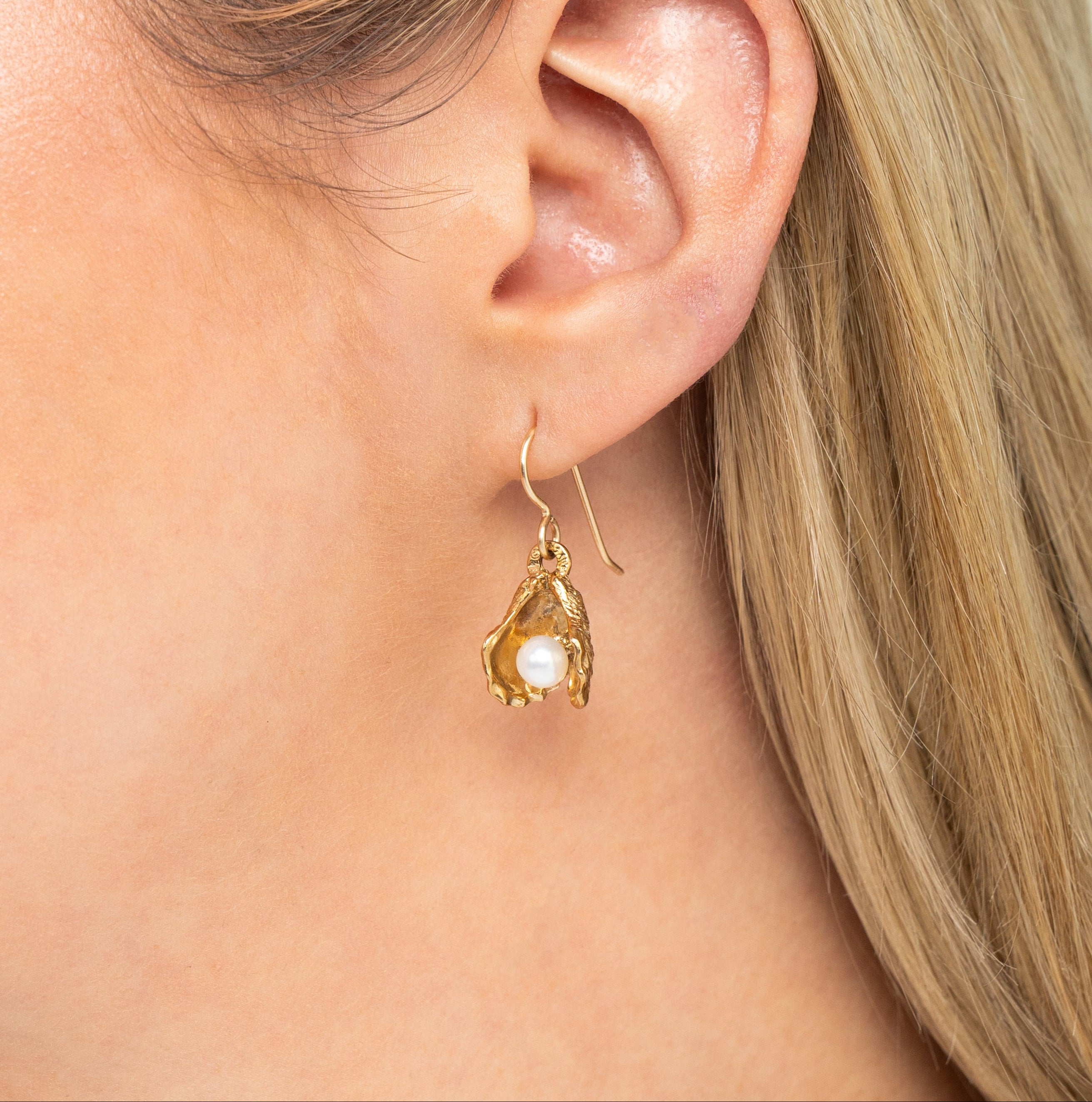 bronze oyster pearl drop earrings worn on ear with freshwater pearl detail