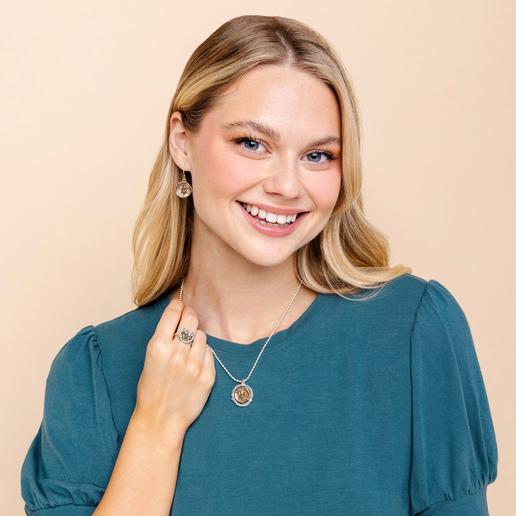 Model wearing fleur de lis doubloon pendant necklace