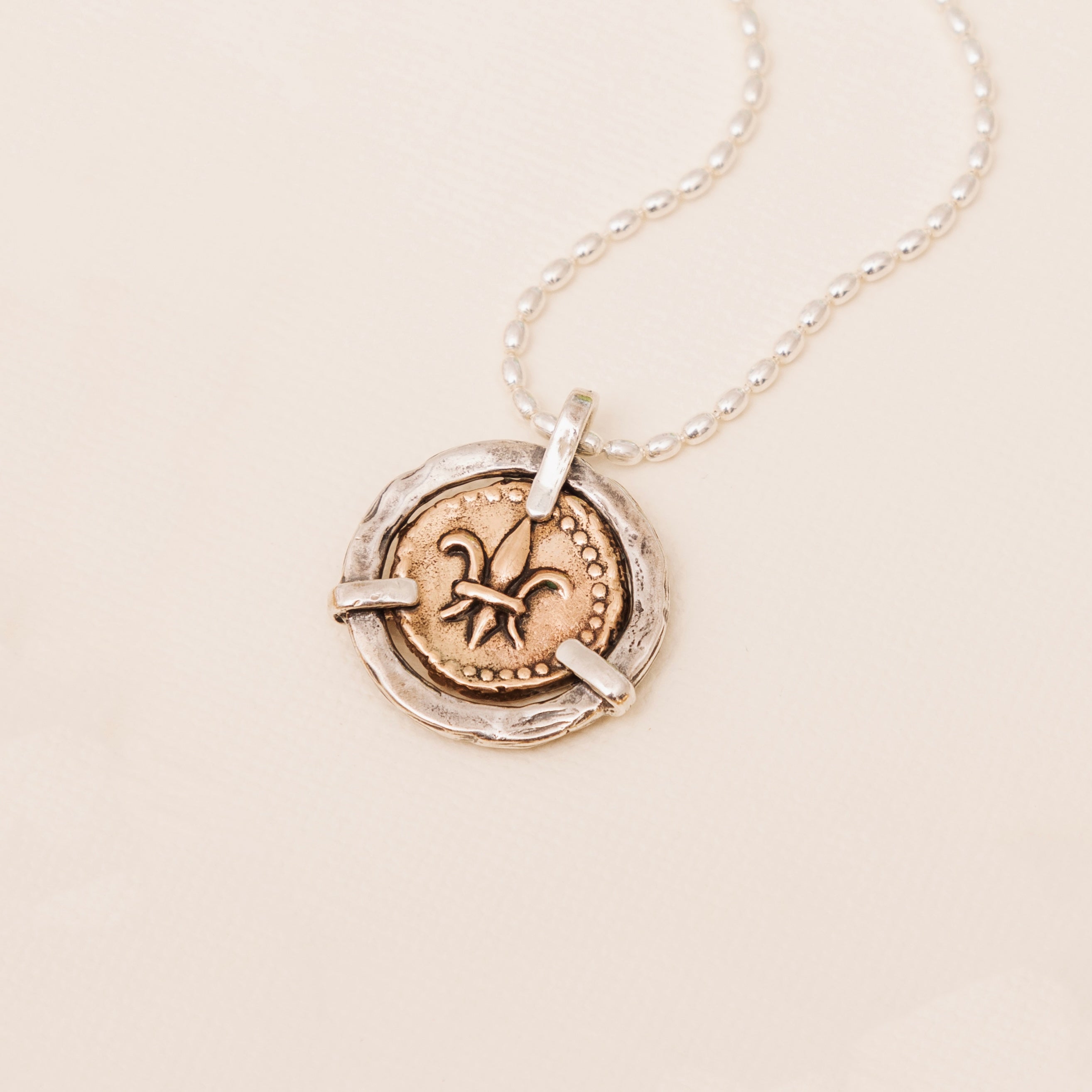 Fleur de lis doubloon pendant with bronze coin in sterling silver bezel