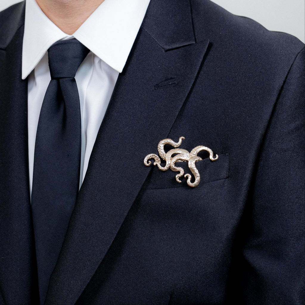 Gilded bronze kraken pocket square worn in formal black suit jacket with tie