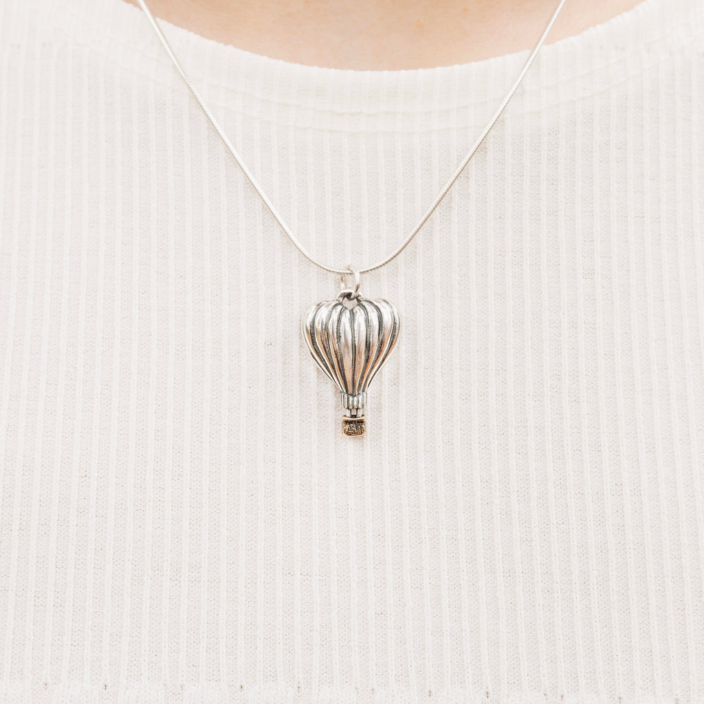 Close-up of heart-shaped hot air balloon pendant with bronze basket