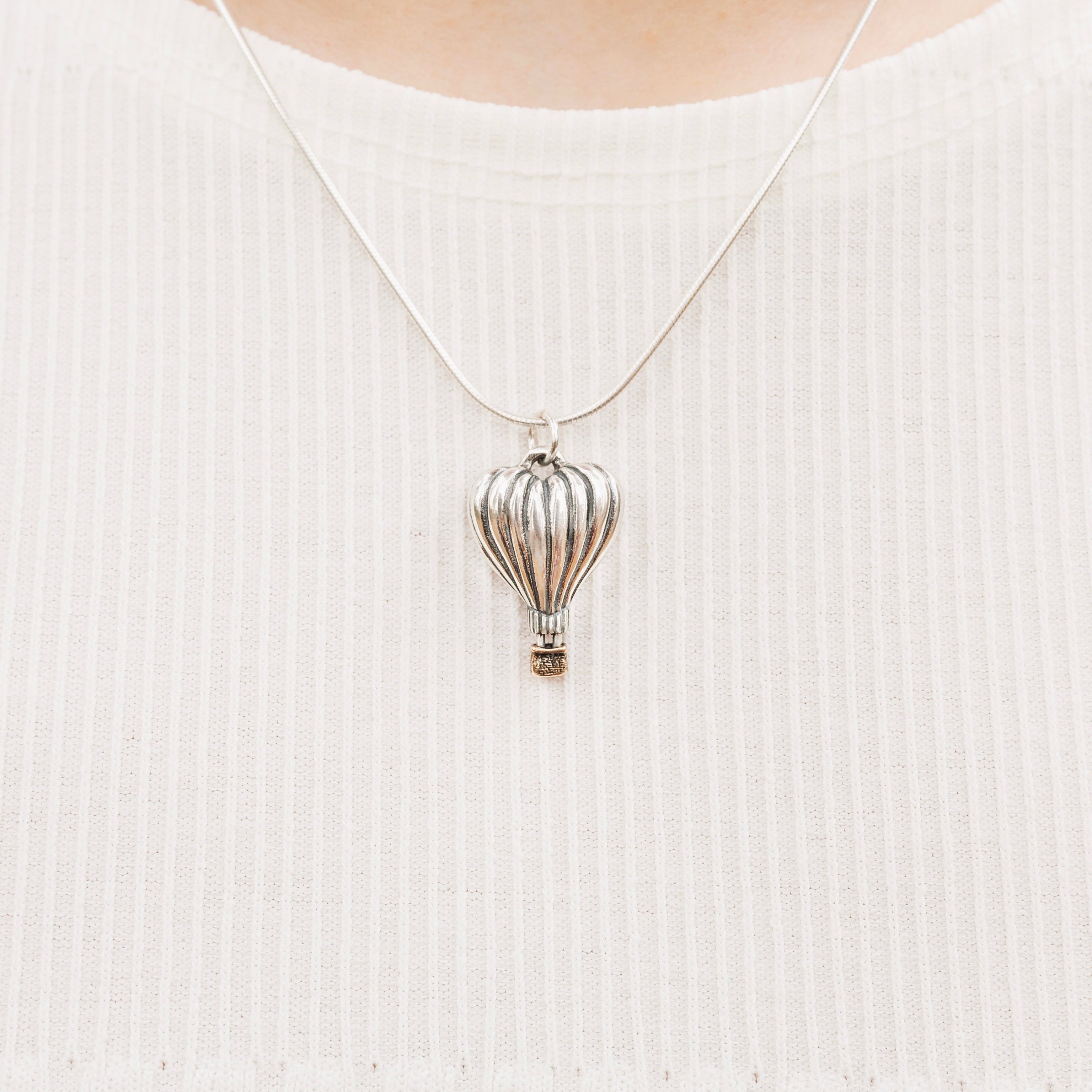 Close-up of heart-shaped hot air balloon pendant with bronze basket