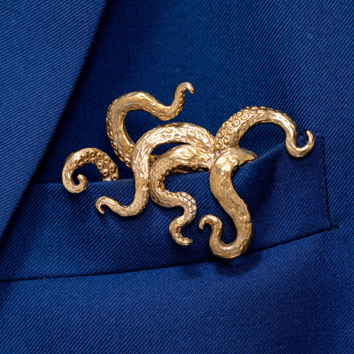 Gilded bronze kraken pocket square worn in blue suit jacket