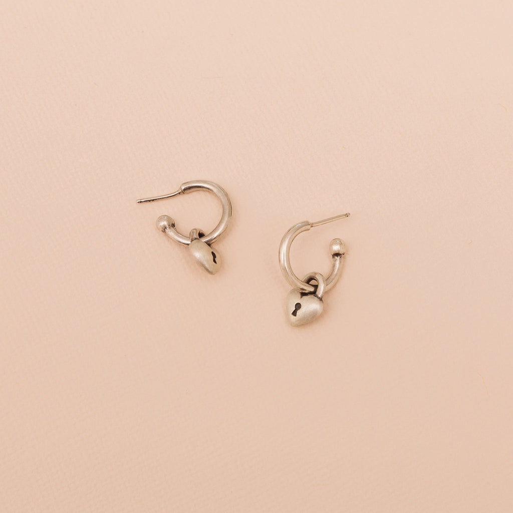 Sterling silver Love Lock heart hoop earrings with removable heart lock charms on a neutral background