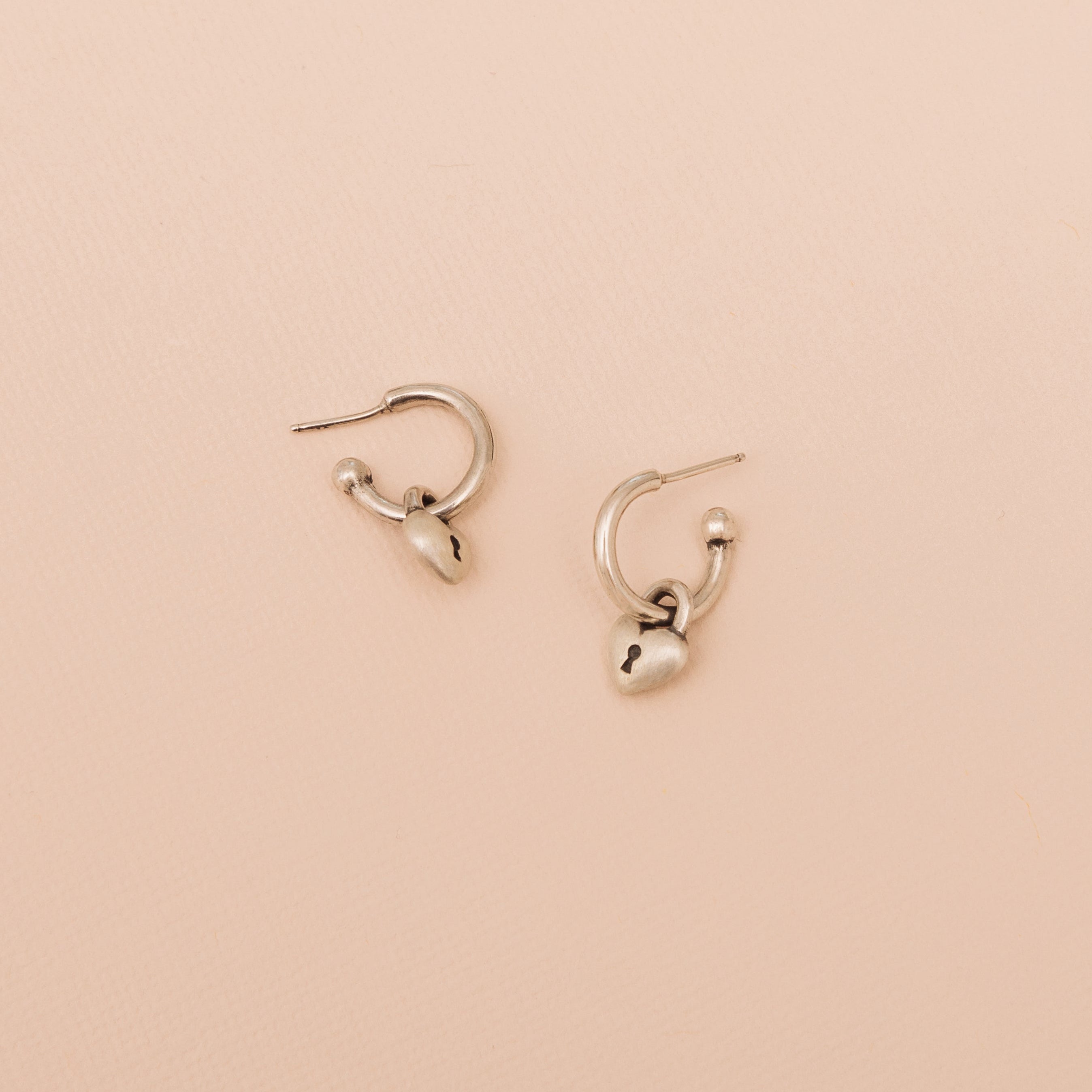 Sterling silver Love Lock heart hoop earrings with removable heart lock charms on a neutral background
