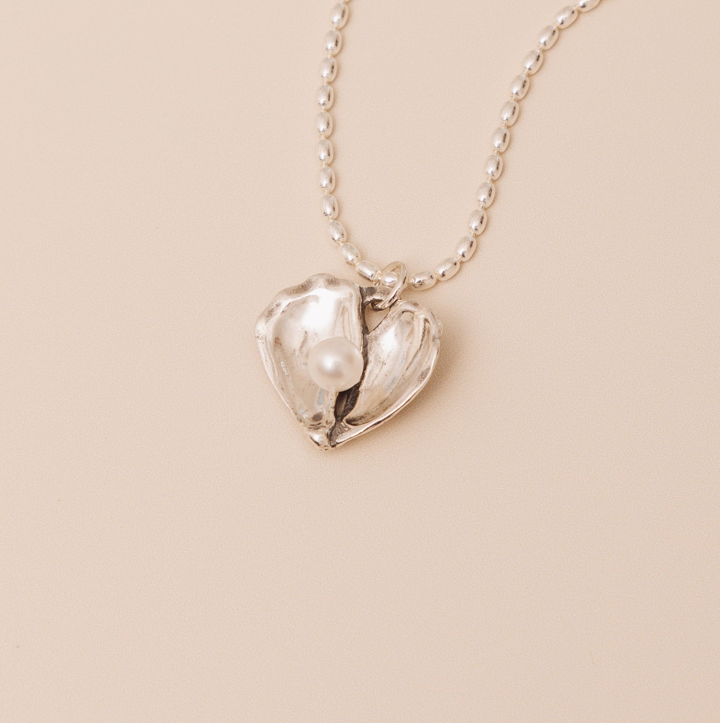 oyster heart pendant detail flat lay close up 