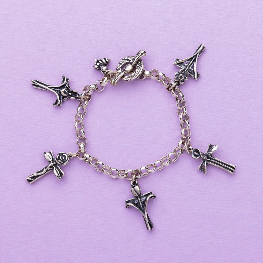 petals and prayers charm bracelet sterling silver cross flower bracelet flat lay detail close up 