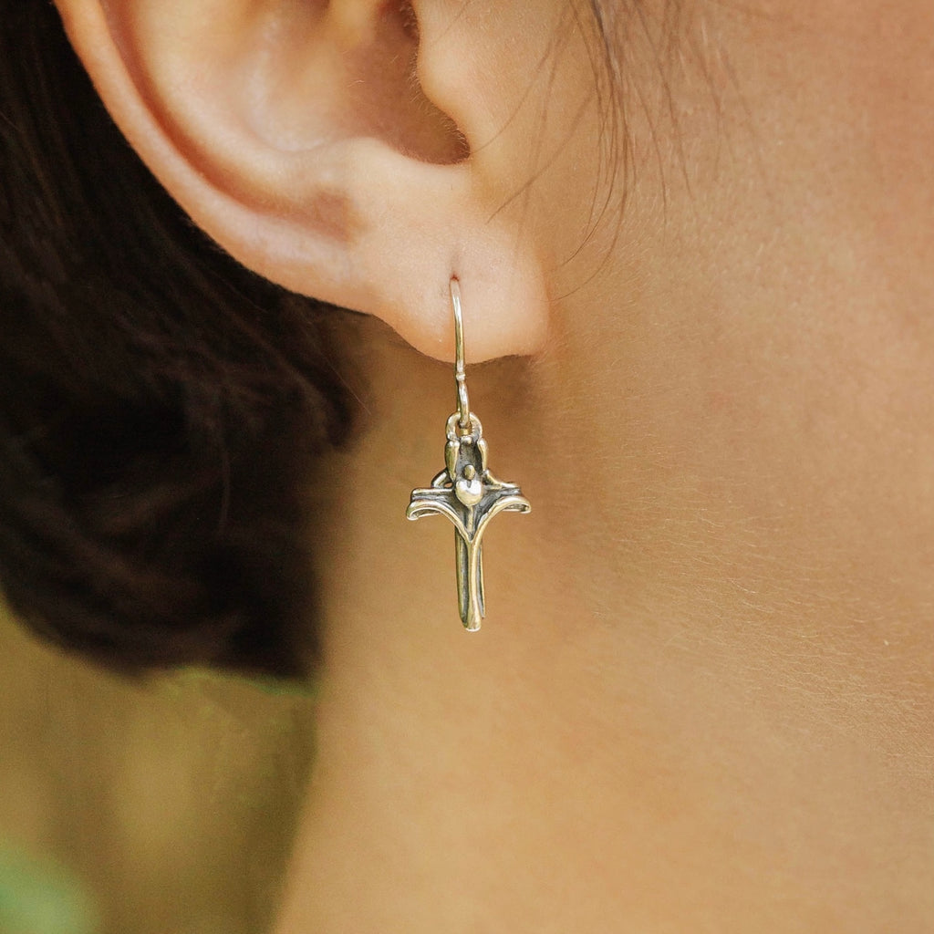 petite iris cross earrings worn on ear sterling silver flower cross design