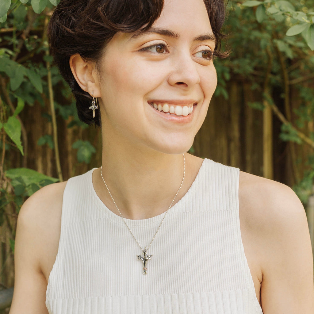 woman wearing petite sterling silver iris cross earrings necklace set