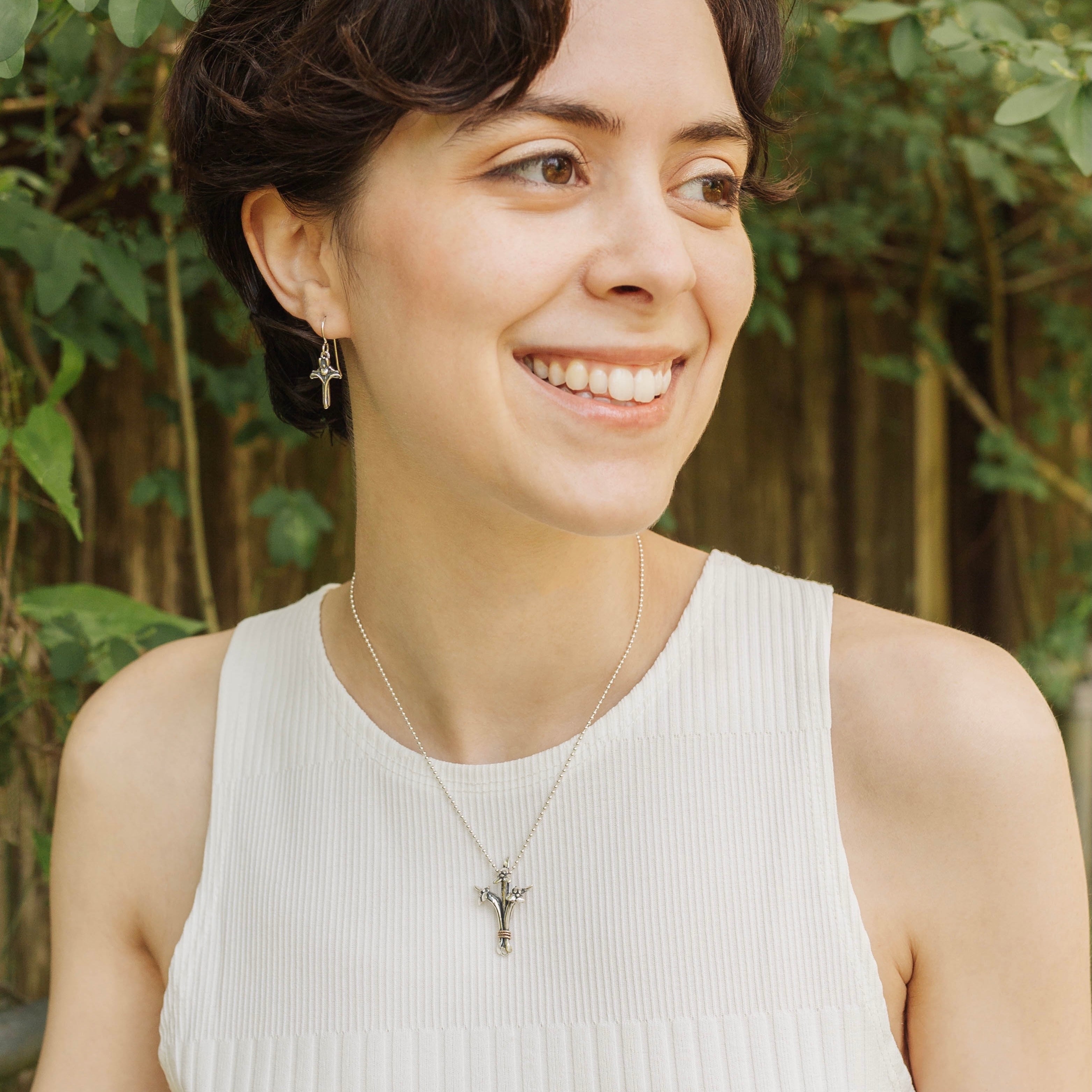 woman wearing petite sterling silver iris cross earrings necklace set