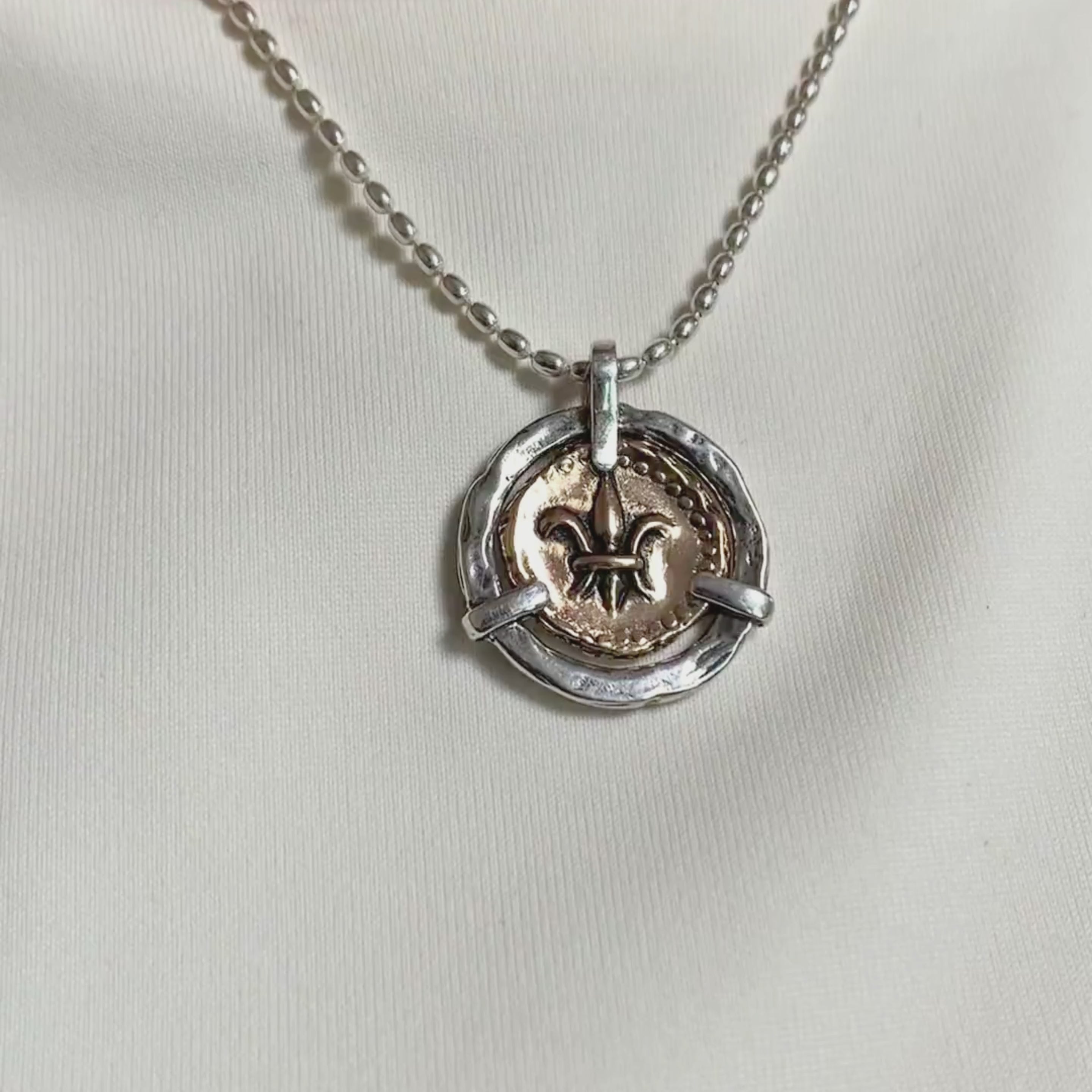 Video showing fleur de lis doubloon pendant necklace