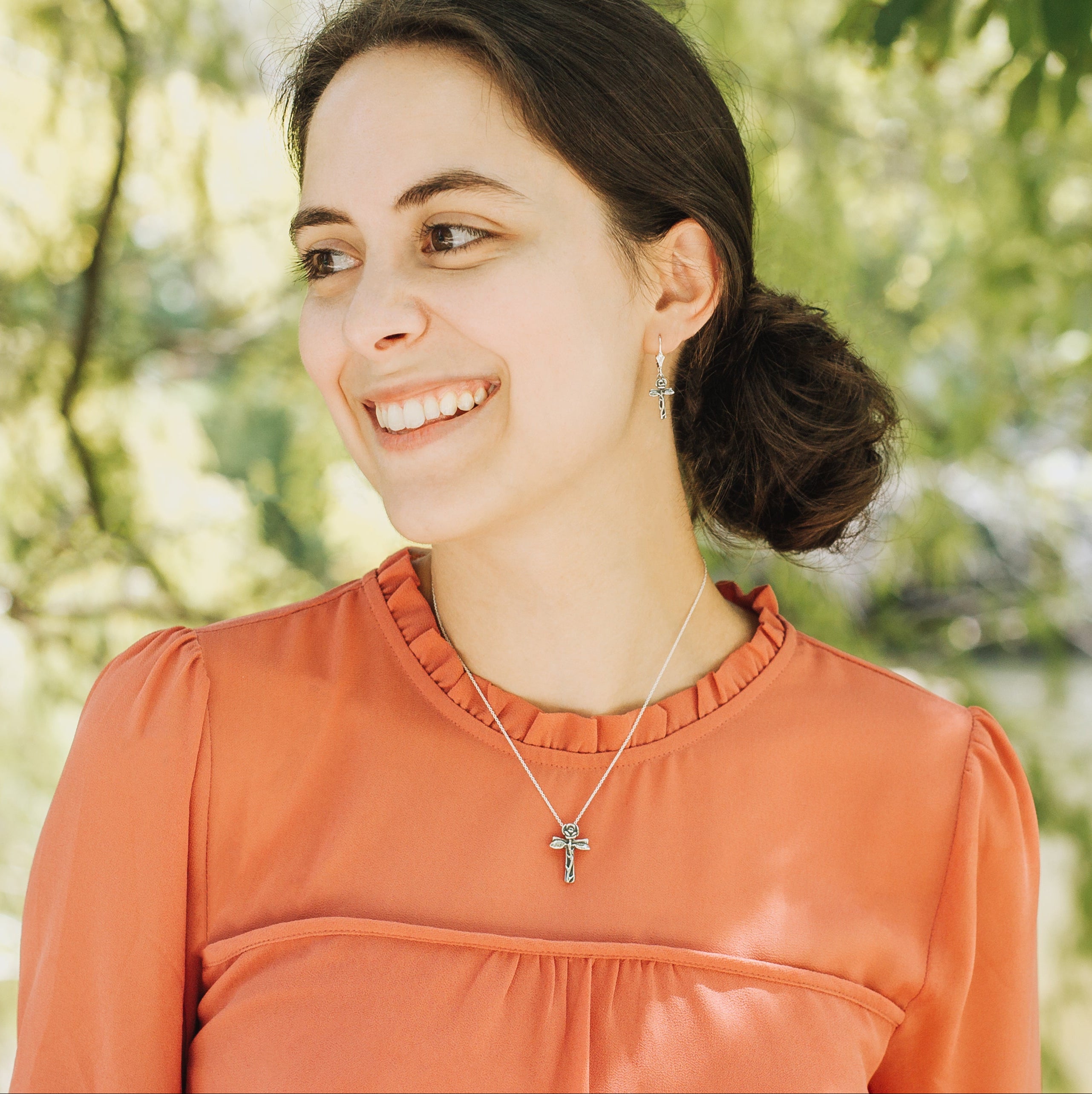 petite rose cross earrings worn on model