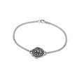 Silver bracelet with a wax stamp-shaped clasp on a white background