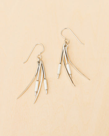 a pair of earrings on a wood surface