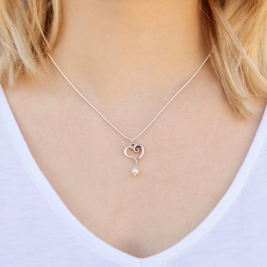Woman wearing sterling silver heart pearl pendant necklace