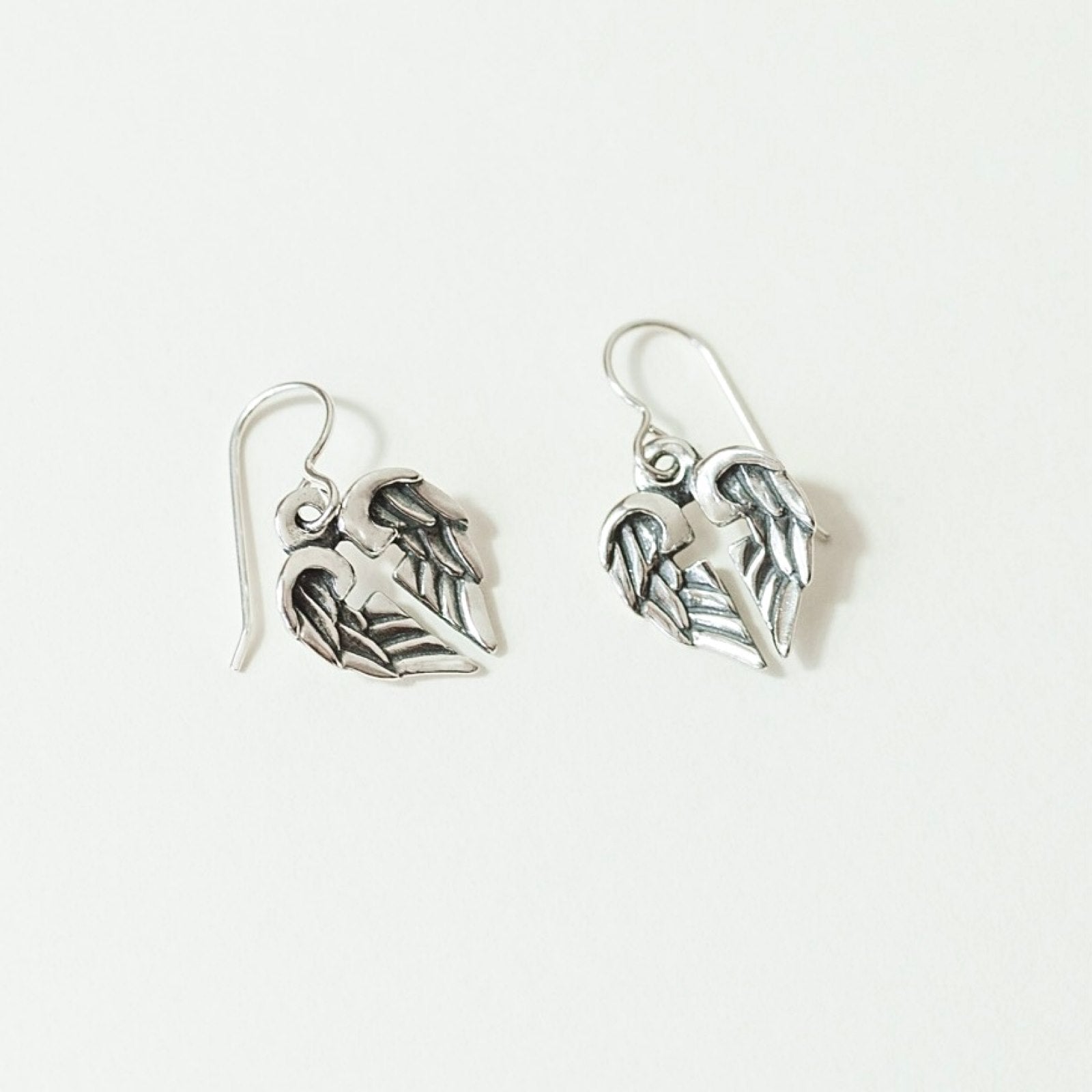 close up of sterling silver angel wing cross earrings