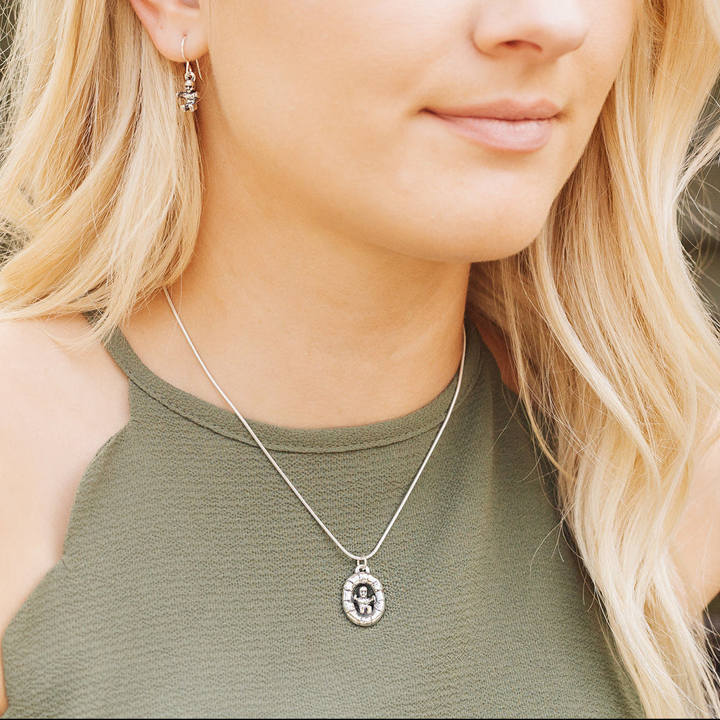 Woman wearing Baby in King Cake sterling silver necklace inspired by Mardi Gras