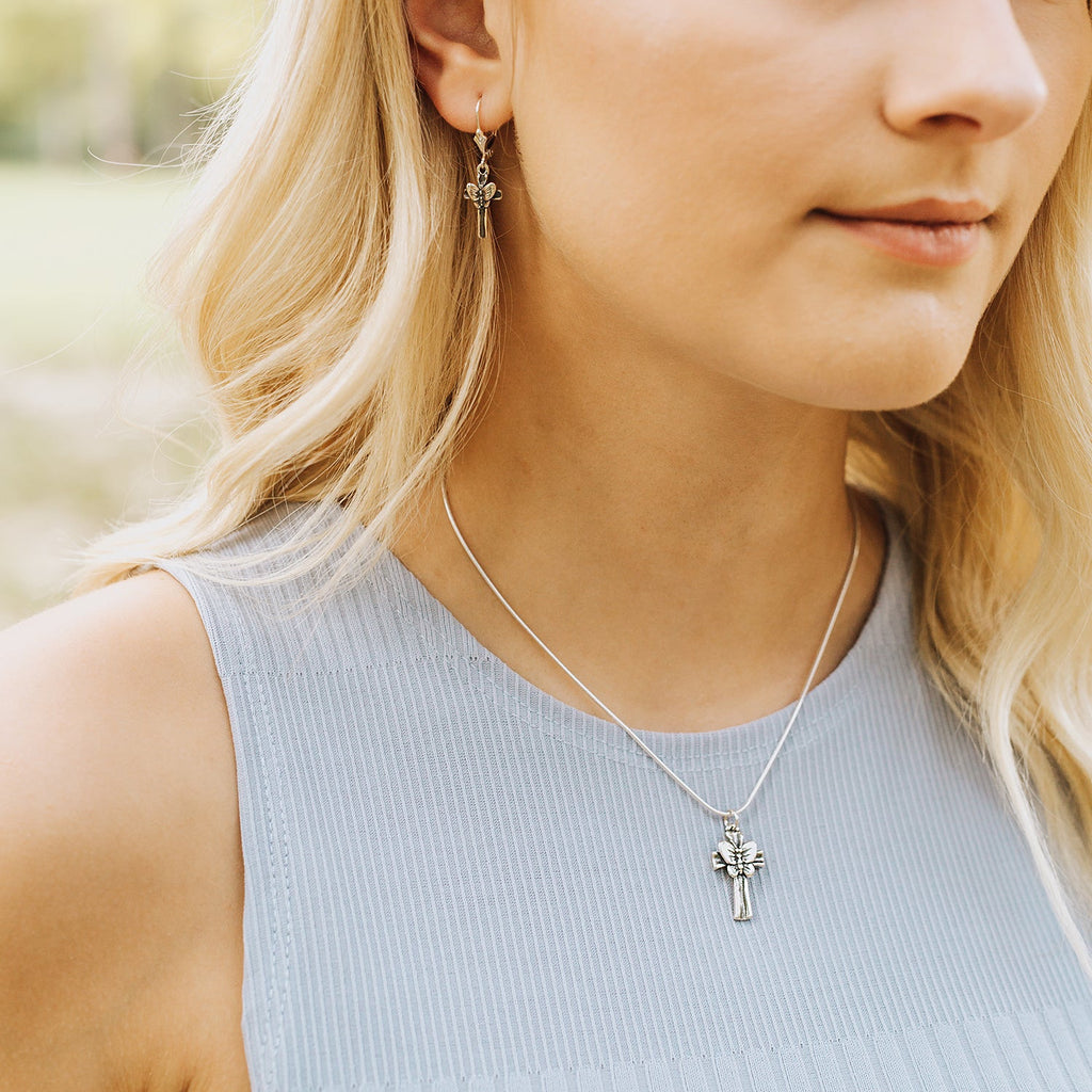 Woman wearing butterfly cross pendant necklace