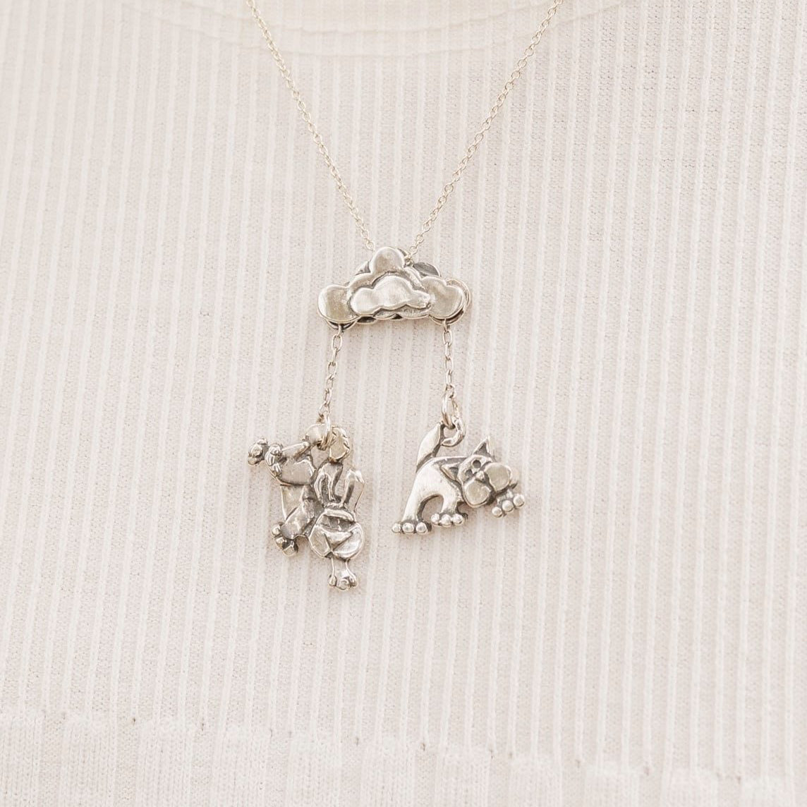 Sterling silver cloud pendant with dangling cat and dog design