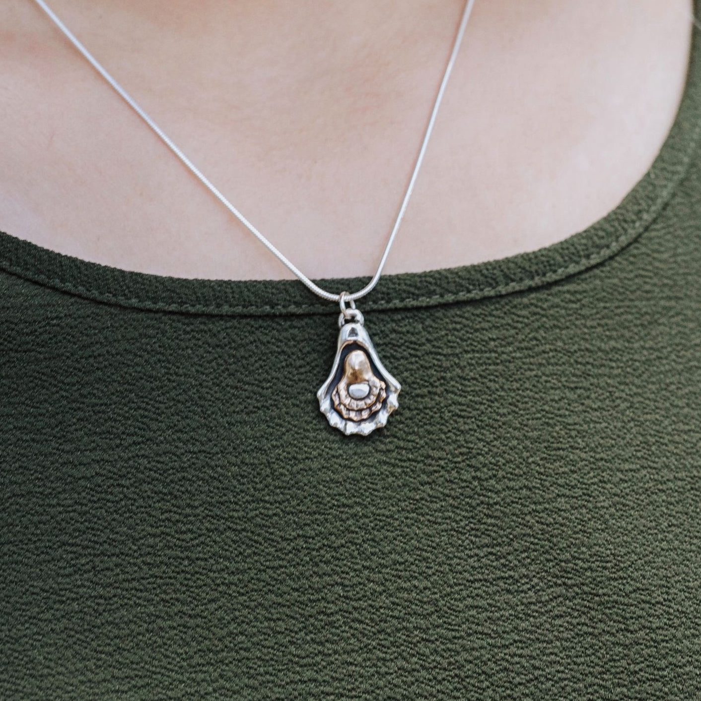 woman wearing charbroiled oyster pendant sterling silver and bronze