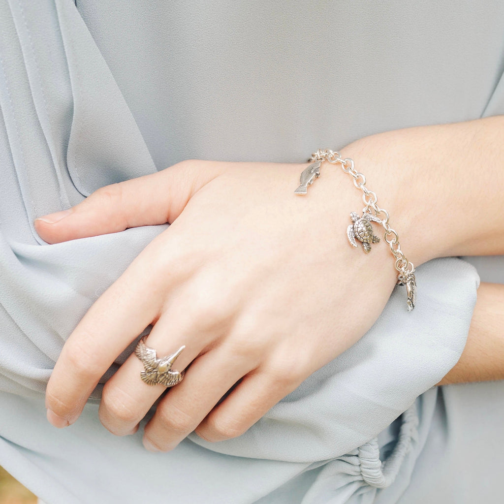 sterling silver charm bracelet worn on wrist with pelican crab oyster turtle charms, new orleans jewelry