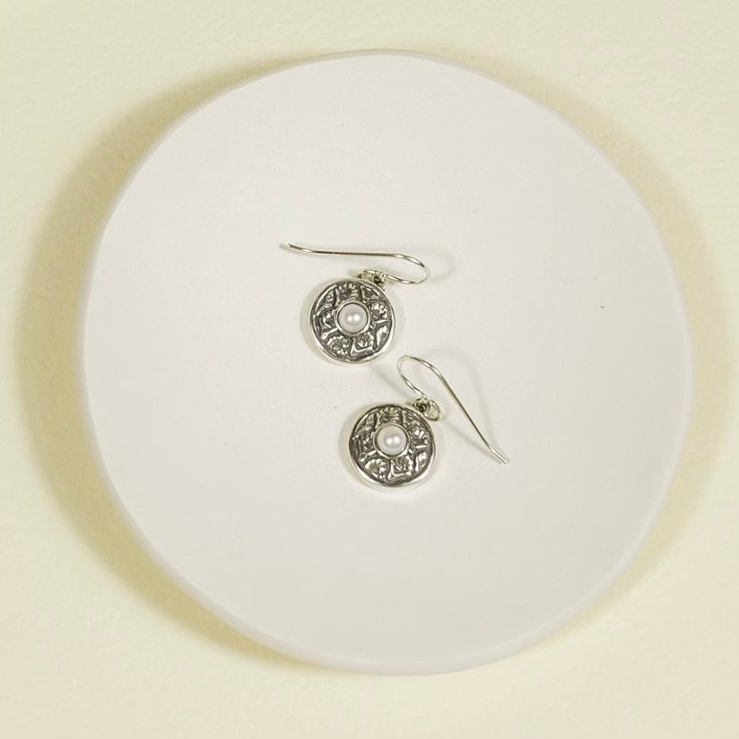 sterling silver coquille oyster pearl earrings displayed on surface showing detail and shape