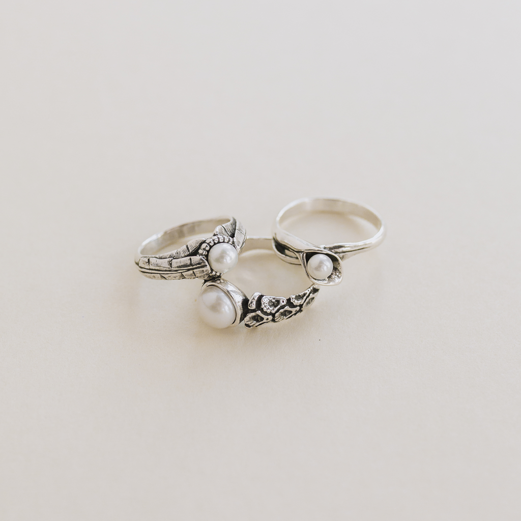side view of coquille oyster pearl ring highlighting carved band texture and pearl setting
