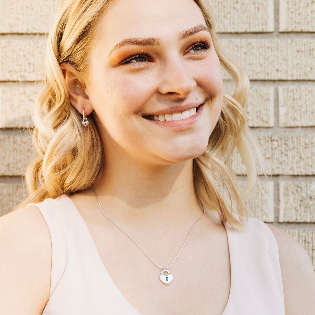 Sterling silver Love Lock heart hoop earrings worn as everyday romantic jewelry