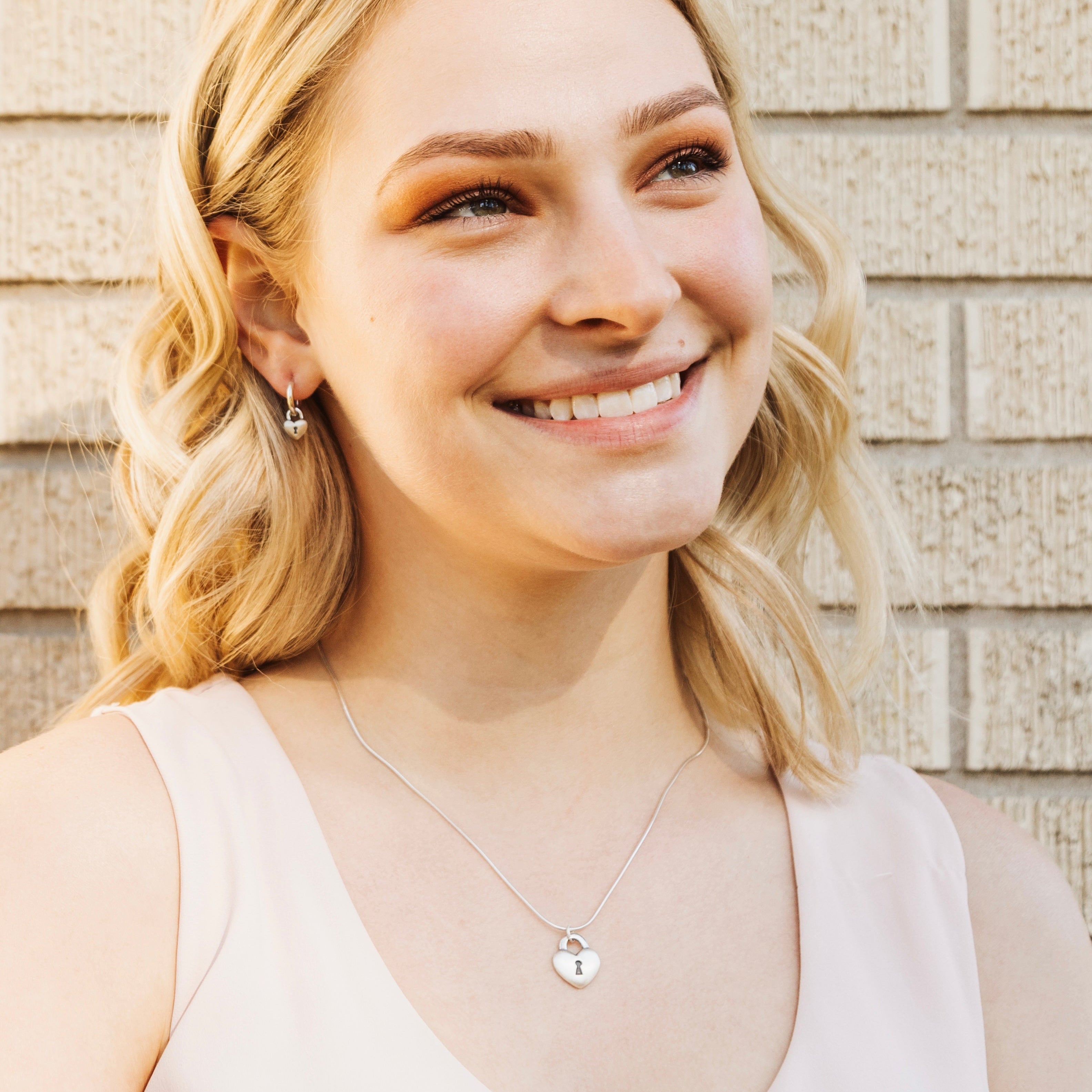 Sterling silver Love Lock heart hoop earrings worn as everyday romantic jewelry