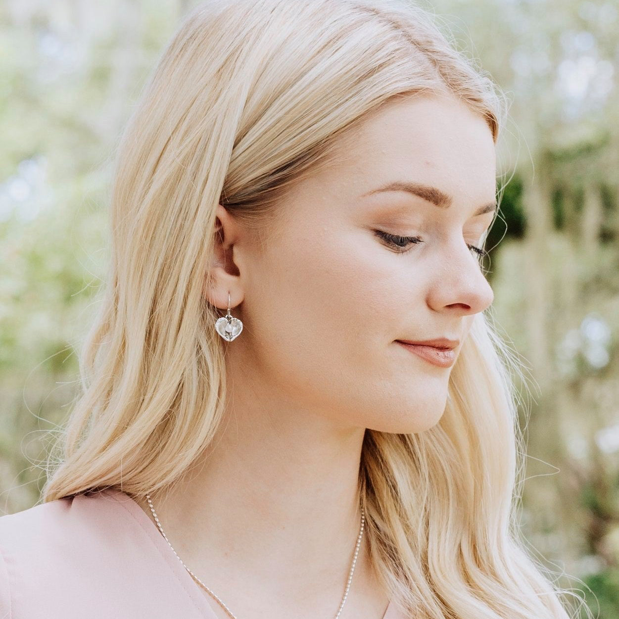 woman wearing oyster heart earrings — feminine everyday jewelry