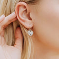 sterling silver oyster heart earrings worn on ear with freshwater pearl detail