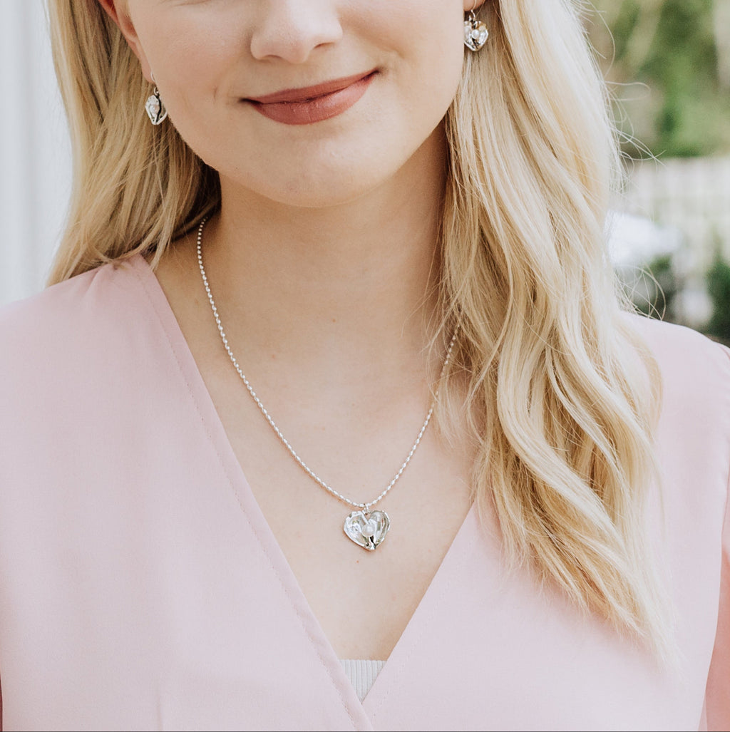 oyster heart necklace worn with soft pink outfit — meaningful everyday jewelry