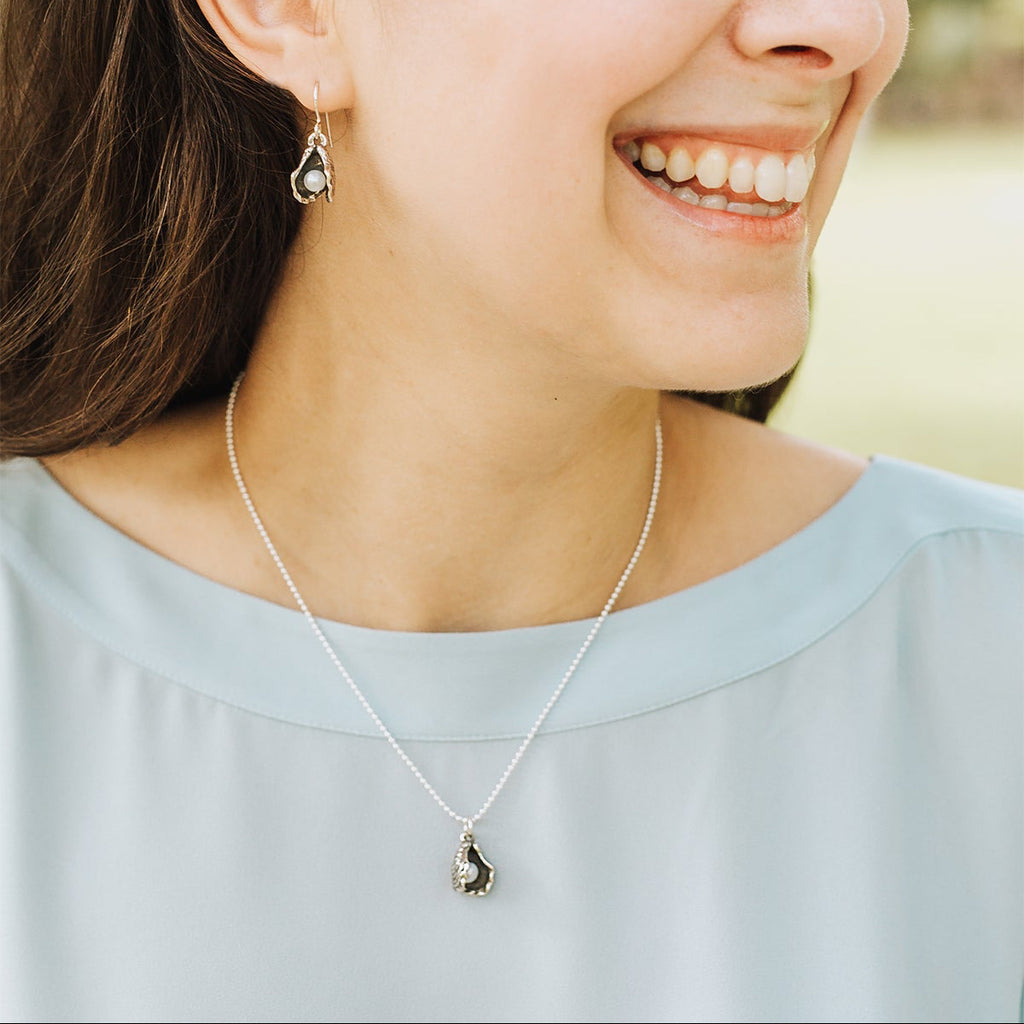 woman wearing oyster pearl pendant necklace subtle everyday jewelry with freshwater pearl