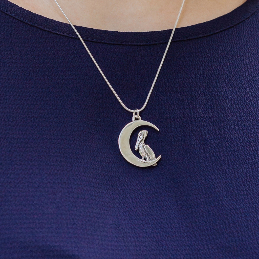 pelican moon pendant worn on necklace, crescent moon and pelican design inspired by new orleans crescent city