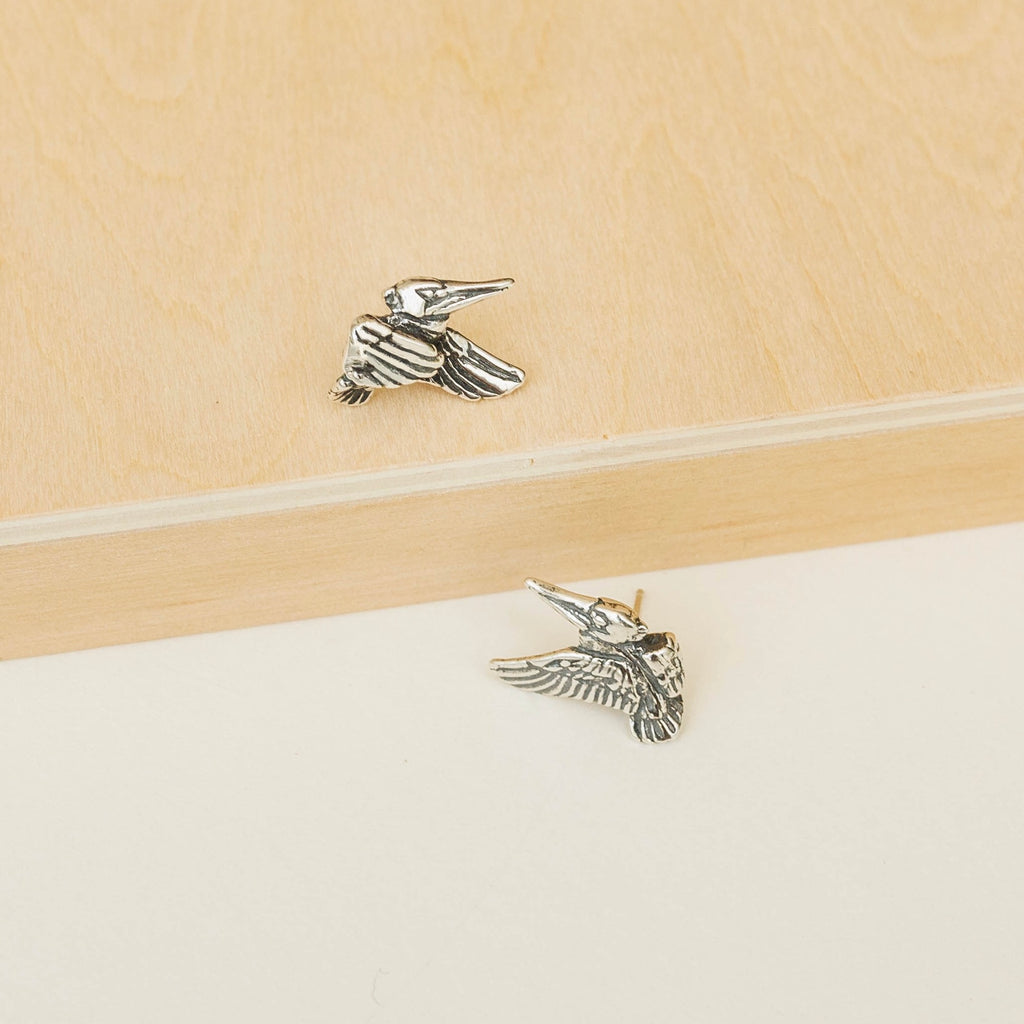 sterling silver pelican post earrings on surface showing detailed bird design inspired by louisiana state bird