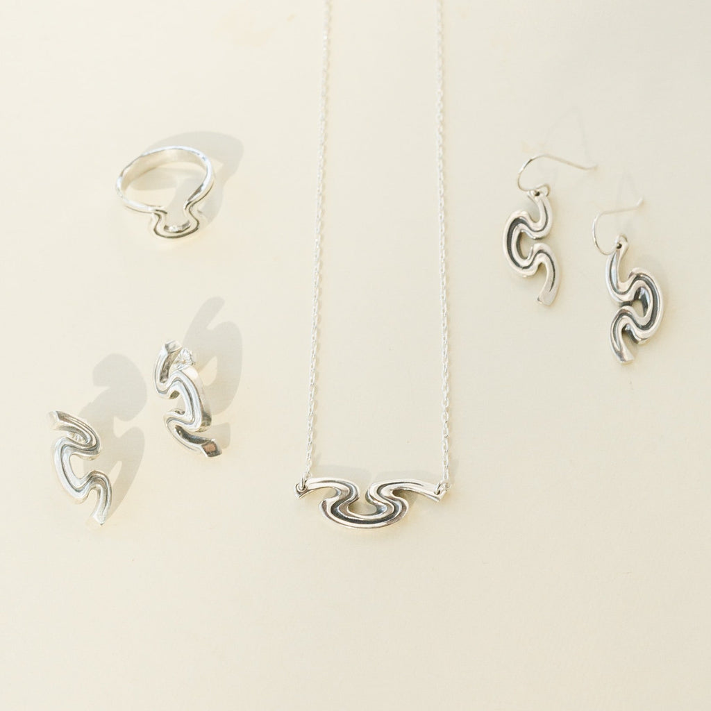 Riverbend jewelry collection featuring sterling silver necklace, earrings, and ring inspired by New Orleans.