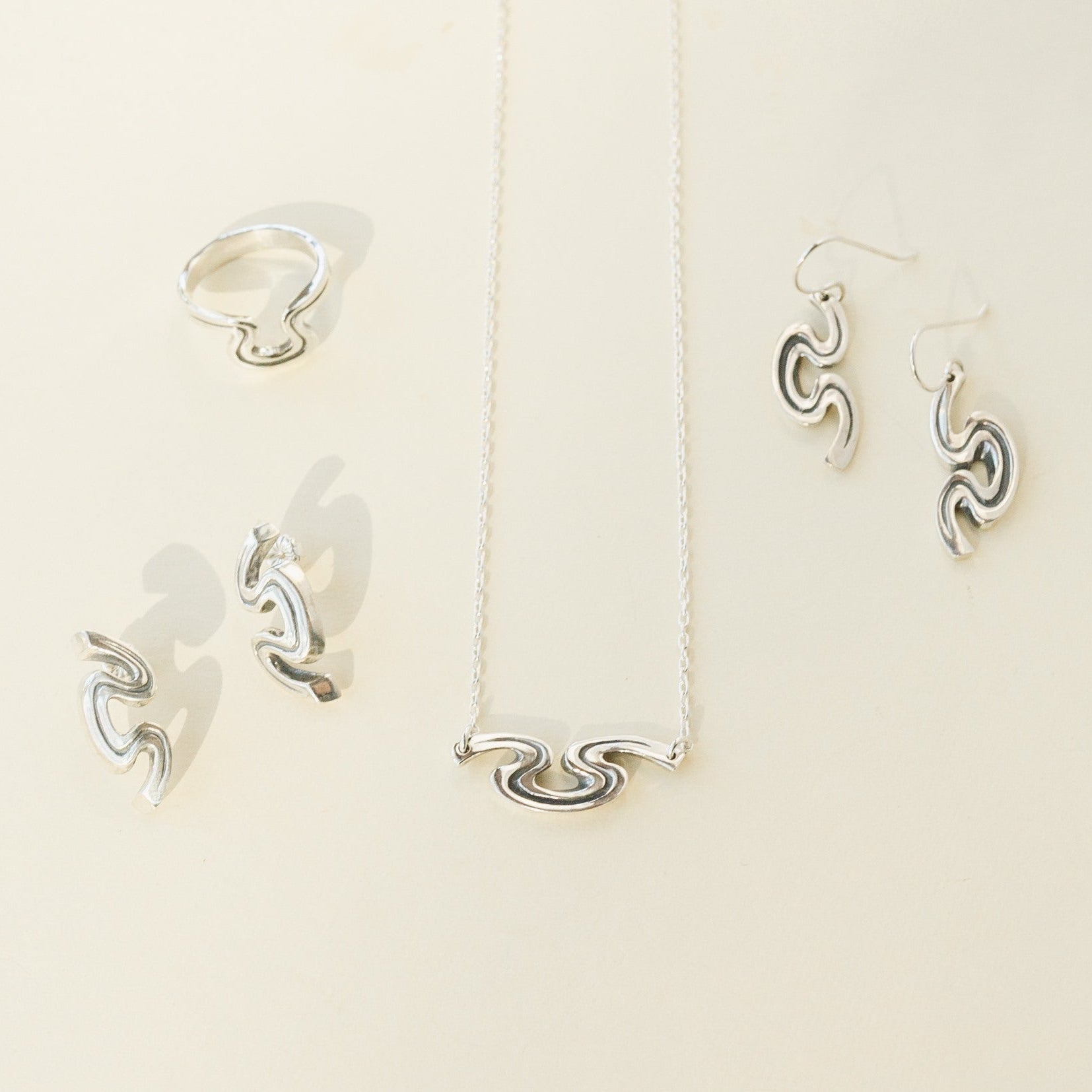 Riverbend jewelry collection featuring sterling silver necklace, earrings, and ring inspired by New Orleans.