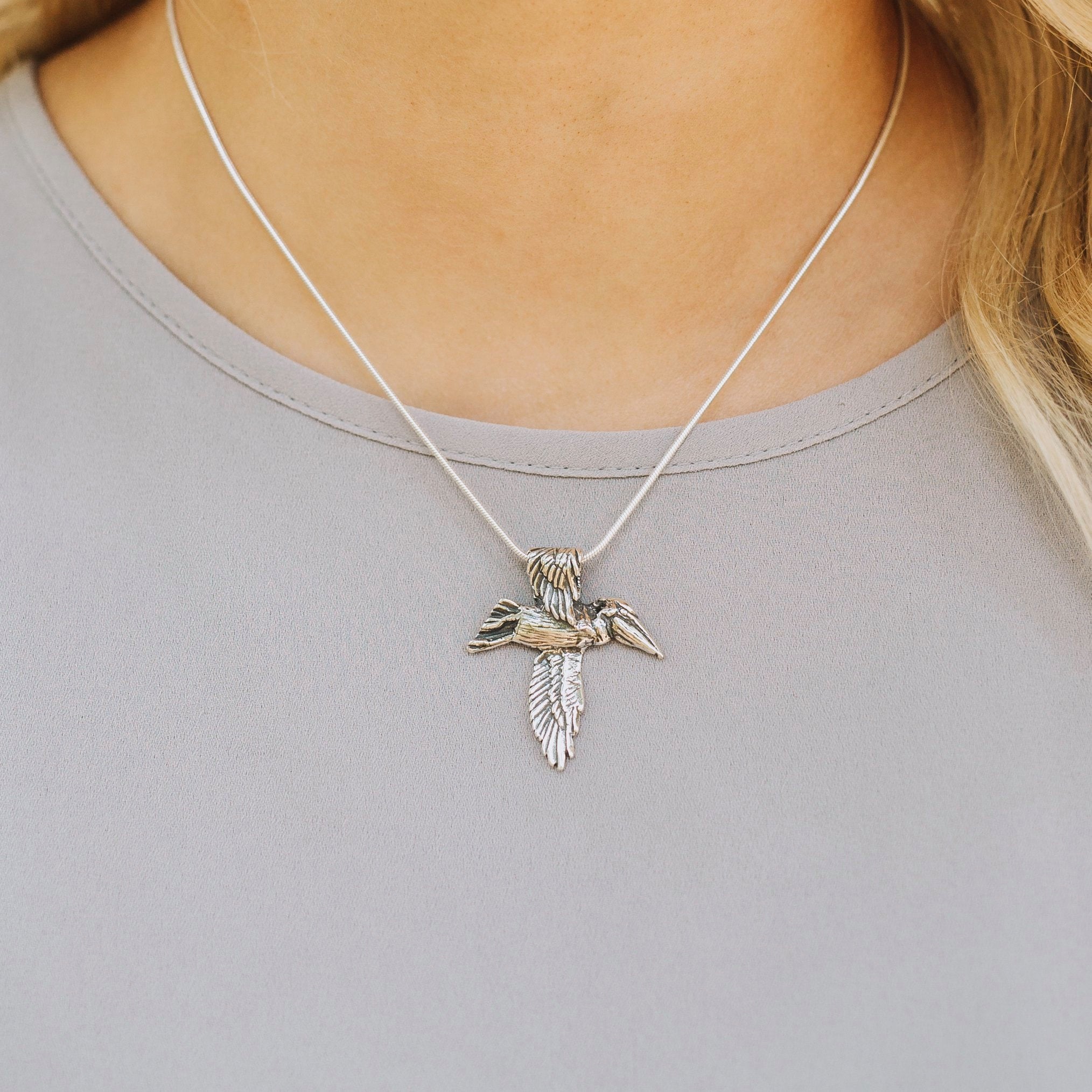 Sterling silver pelican cross necklace worn on model