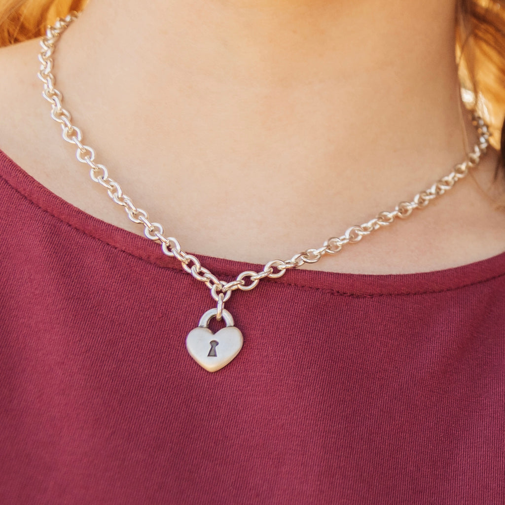 Sterling silver heart lock necklace worn on model showing chunky chain and pendant size